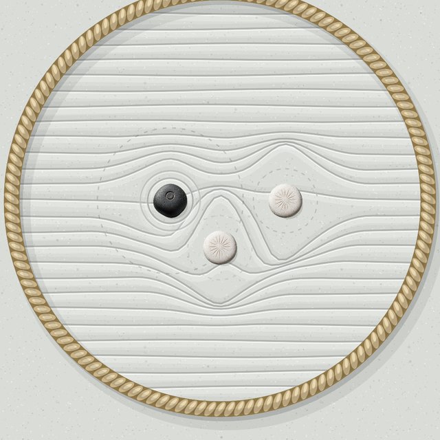 A white push stone between two dark stones, shoving them apart